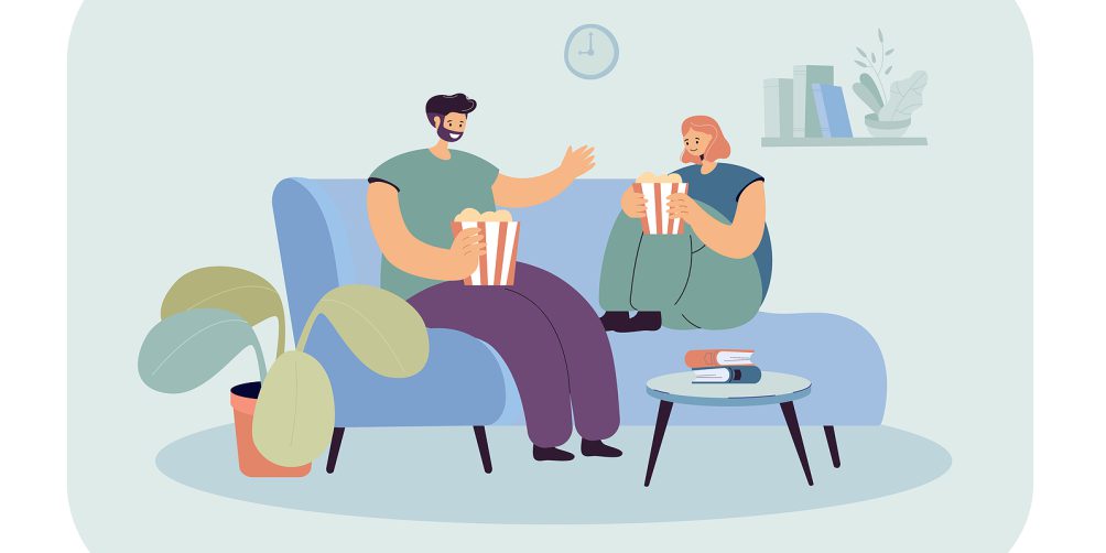 two people on the couch eating popcorn